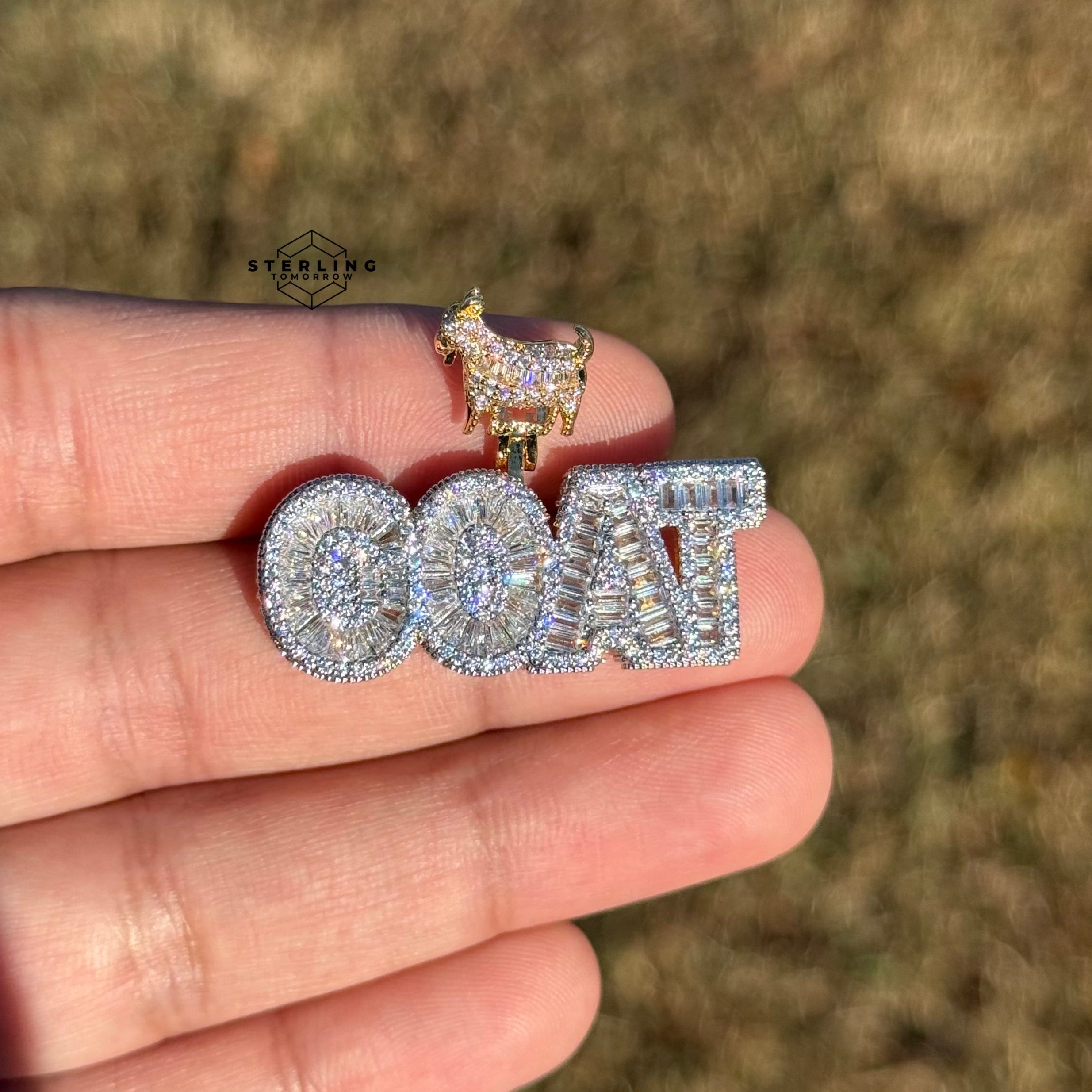 iced out goat pendant held outside in natural sunlight